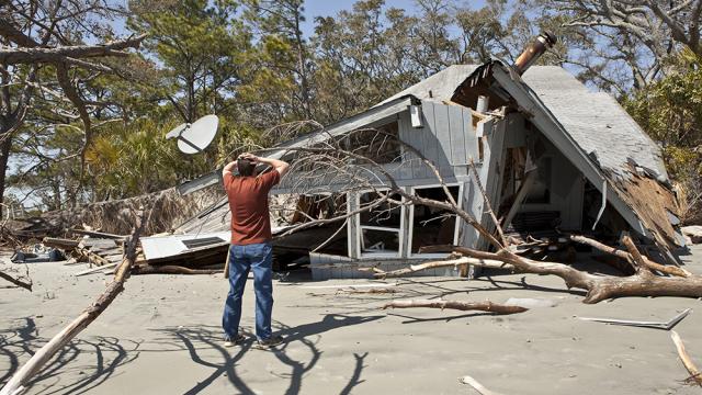 man standing in front of weather damage to a home